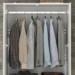 Close-up of a closet interior with several shirts hanging on hangers.