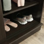 Close-up of a closet with shelves, showing a pair of sandals and a pair of sneakers on the bottom shelf.