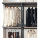 Walk-in closet with hanging rods and drawers.