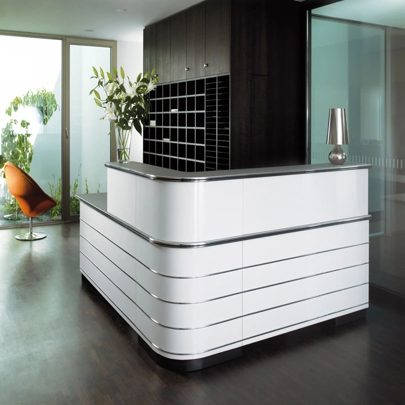A sleek, modern, custom made reception desk with rounded corners, featuring white panels accented by horizontal chrome strips.